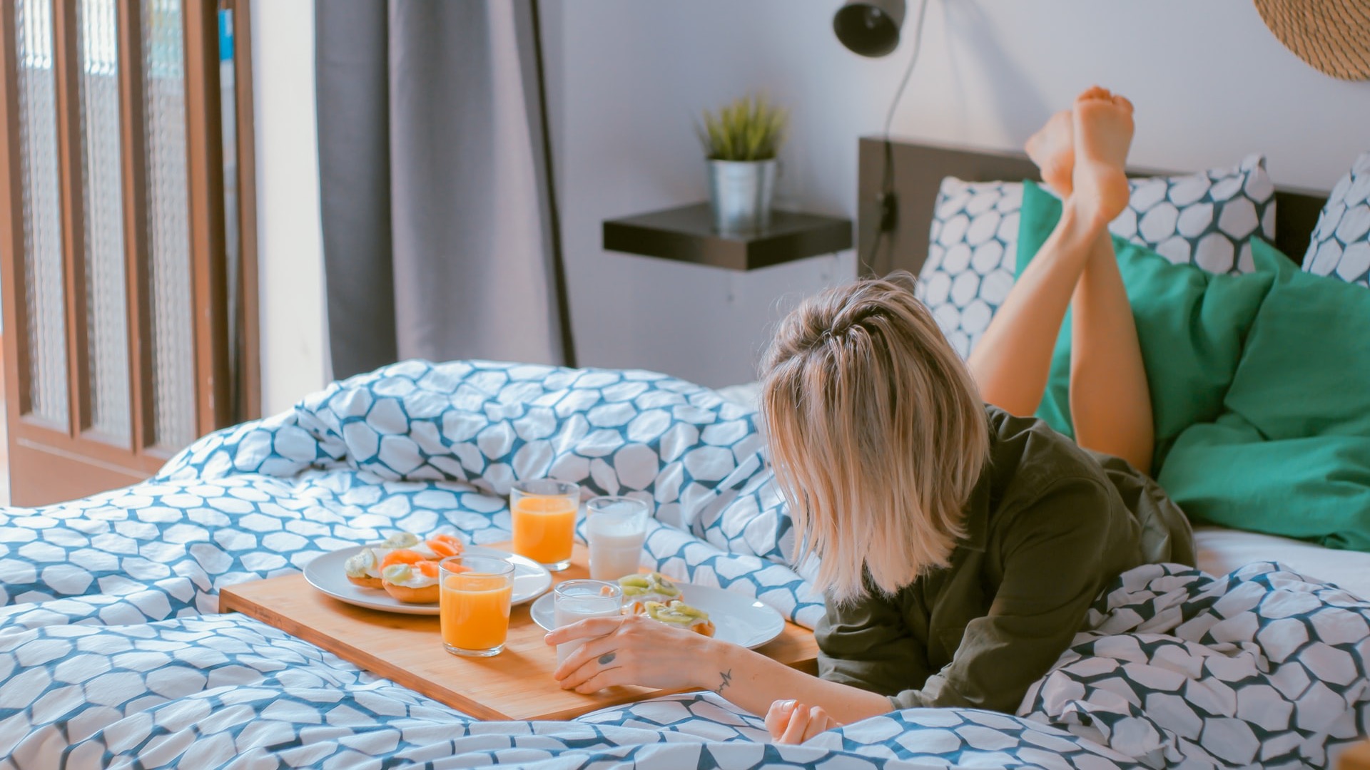 woman lying on bed white holding board